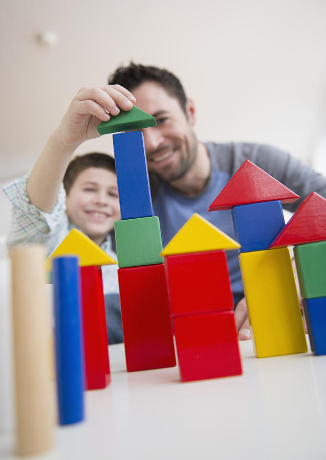 USA, New Jersey, Jersey City, Father stacking blocks with his son (8-9)  Photograph by Jamie Grill