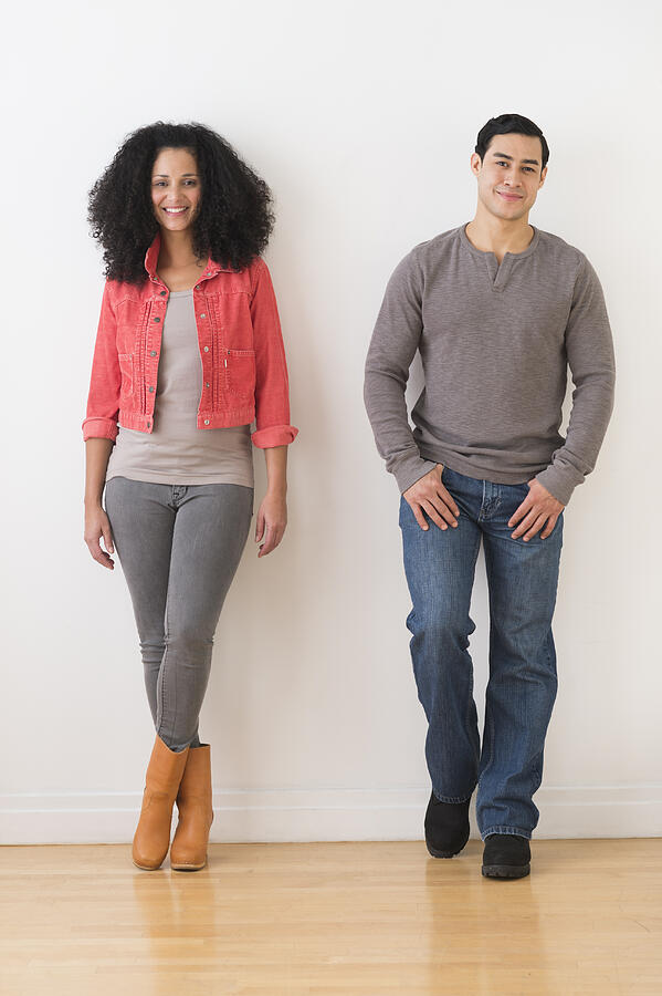 USA, New Jersey, Jersey City, Smiling couple standing against white wall Photograph by Tetra Images
