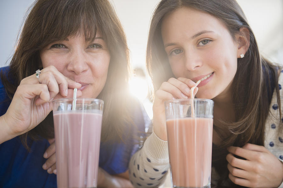 USA, New Jersey, Portrait of mother and daughter (14-15) drinking milkshakes Photograph by Jamie Grill