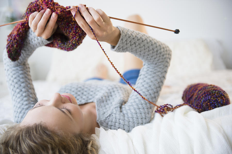 USA, New Jersey, Young woman lying down and knitting Photograph by Jamie Grill