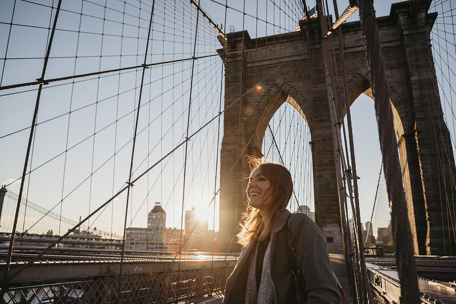 USA, New York, New York City, female tourist on Brooklyn Bridge at sunrise Photograph by Westend61