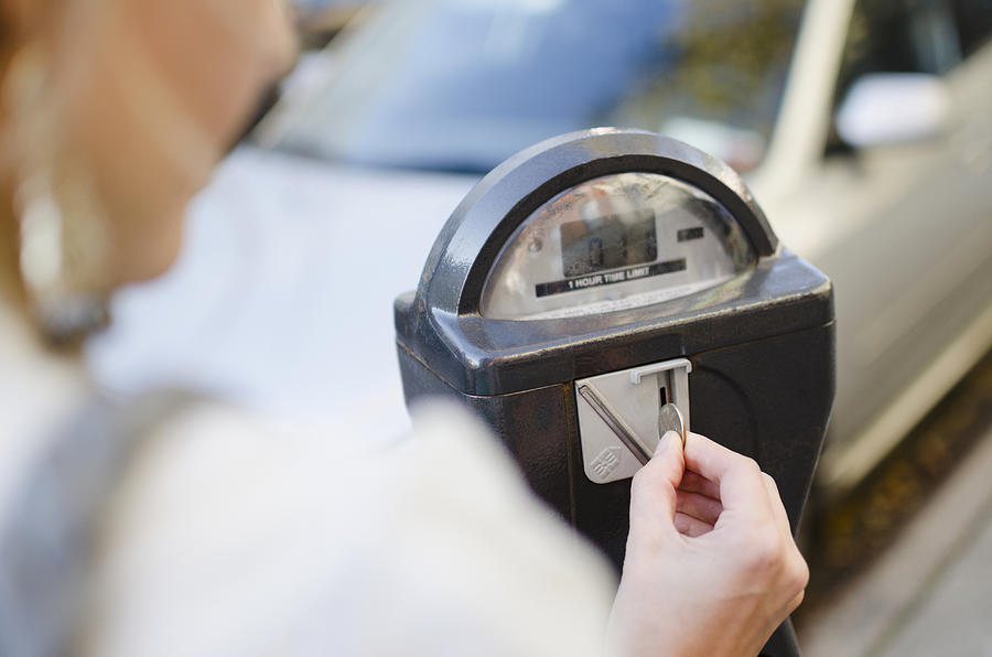 USA, New York State, New York City, Brooklyn, Woman inserting coin into parking meter Photograph by Jamie Grill
