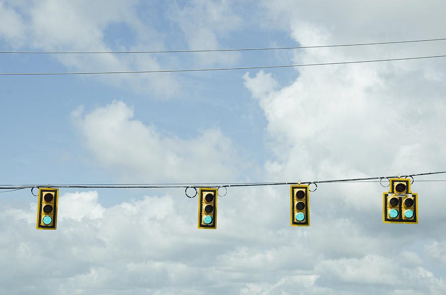 USA, South Carolina, Road signals on cable against cloudy sky Photograph by Chris Hackett/Tetra Images