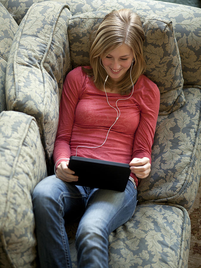 USA, Utah, Cedar Hills, Teenage girl (14-15) lying on listening to music from using digital tablet Photograph by Tyler Marshall