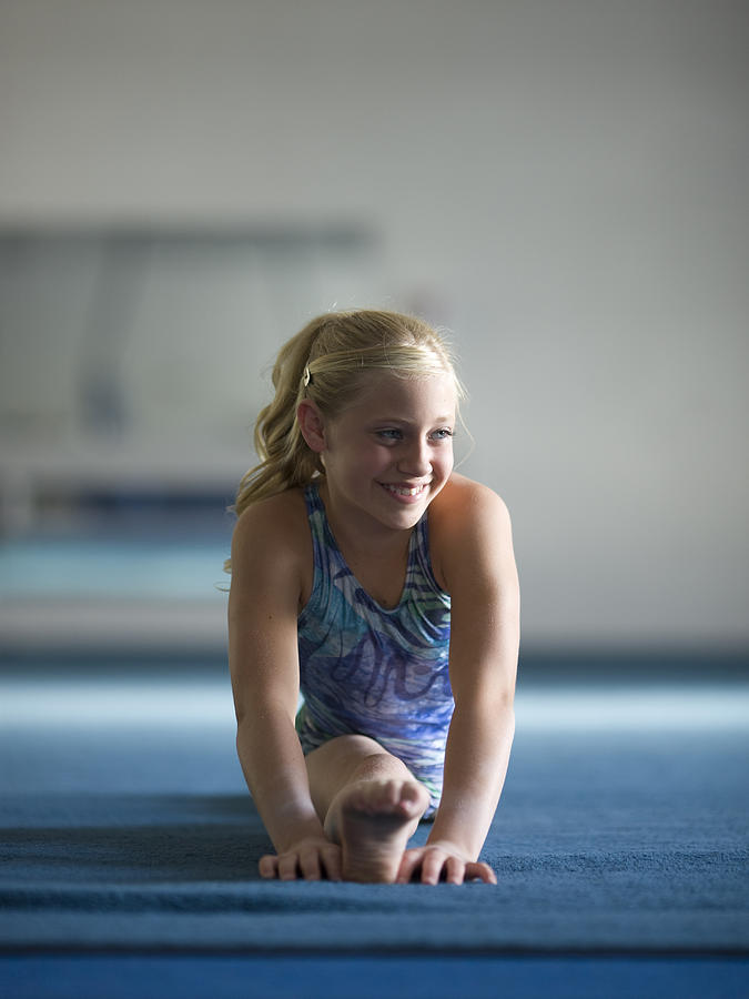 USA, Utah, Orem, girl gymnast (10-11) performing splits Photograph by RubberBall Productions
