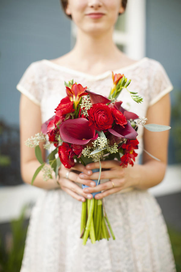 USA, Utah, Provo, Mid section of bride with bouquet in focus Photograph by Tetra Images - Jessica Peterson