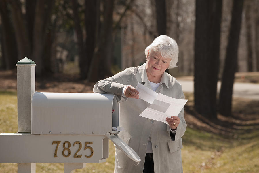 USA, Virginia, Richmond, senior woman reading letters by mailbox Photograph by Mark Edward Atkinson