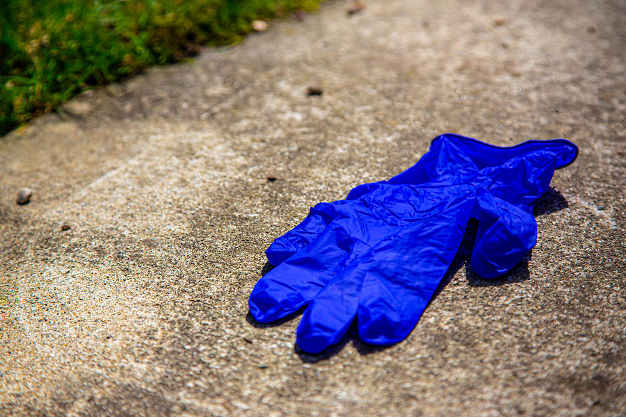 Used glove on pavement Photograph by Photo by Katkami