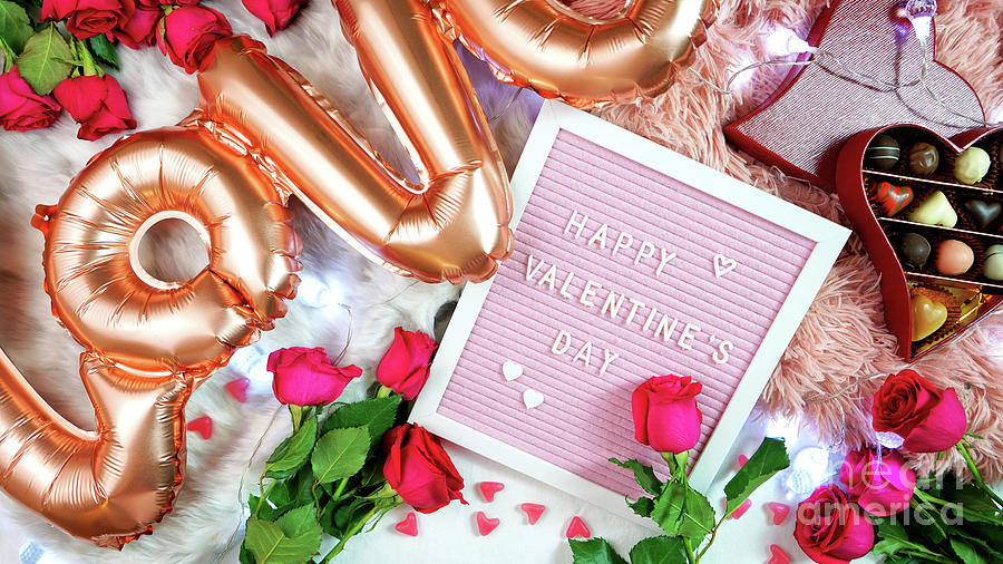 Valentines Day flat lay with roses, chocolates and letterboard. Photograph by Milleflore Images