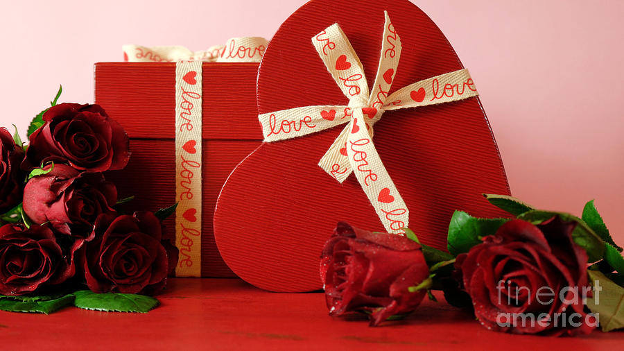 Valentines Day gifts and red roses on red wood table background. Photograph by Milleflore Images