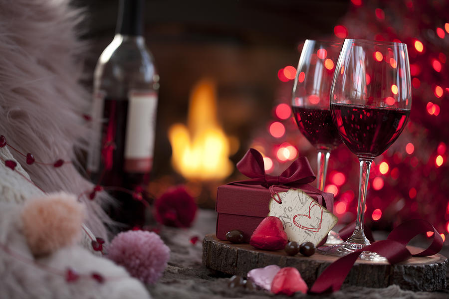 Valentines Day Red Wine and a Gift with Chocolates in Front of the Fireplace Photograph by Liliboas