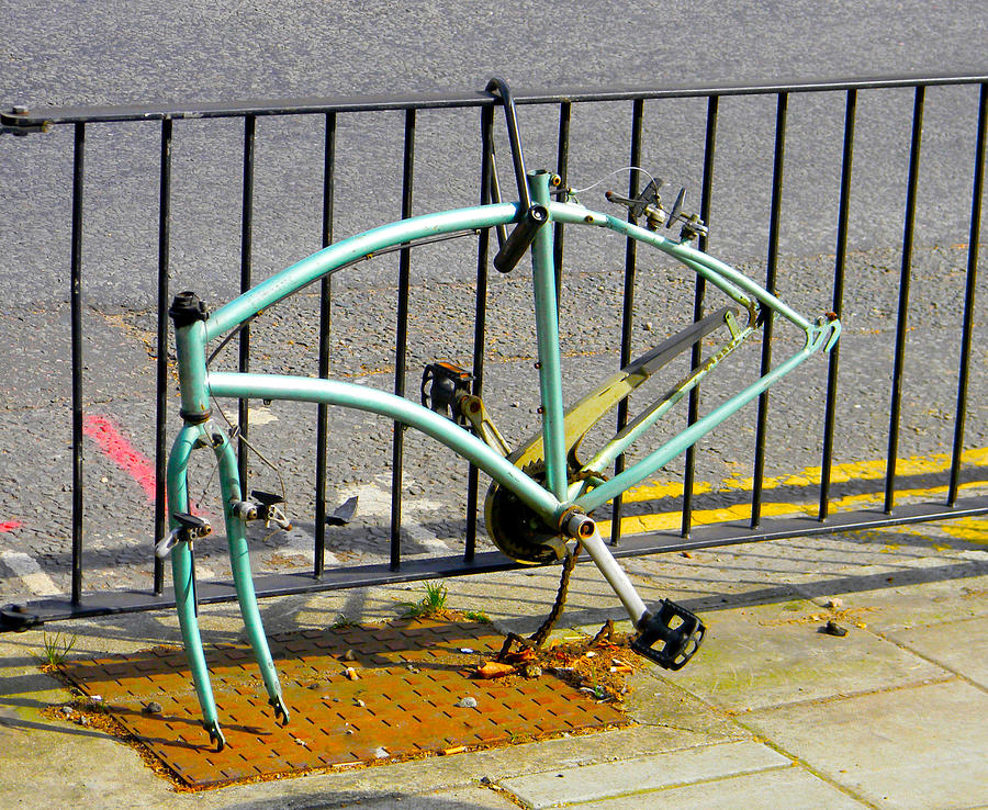 Vandalized bicycle frame chained to a railing - logos removed Photograph by Ian Dennis