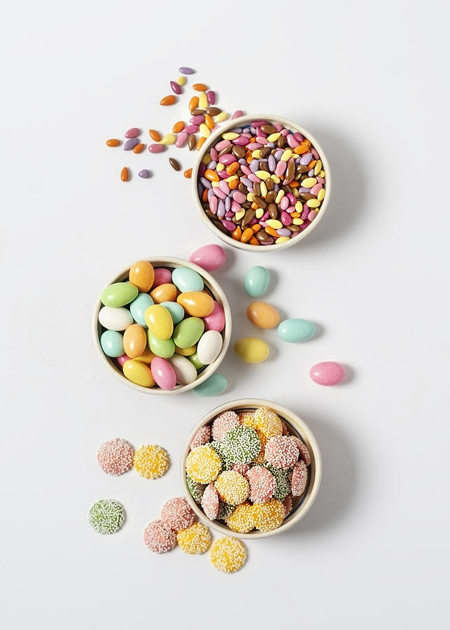 Variety of candy in bowls on white background Photograph by Claudia Totir