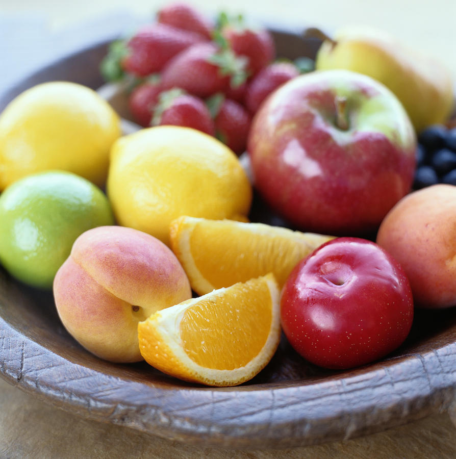 Variety of fruits in a wooden bowl Photograph by Ryan McVay