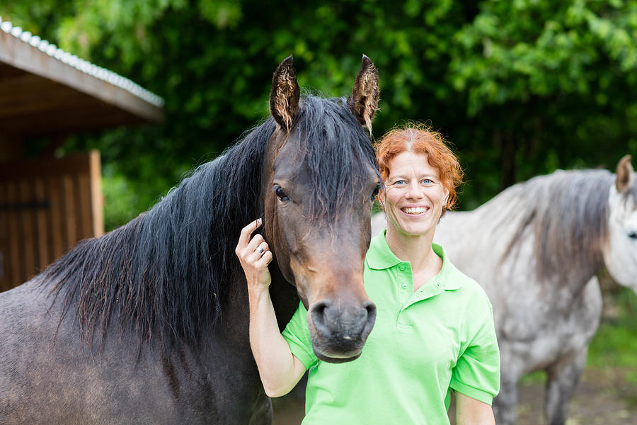 Veterinarian smiling with horses Photograph by Jan-Otto