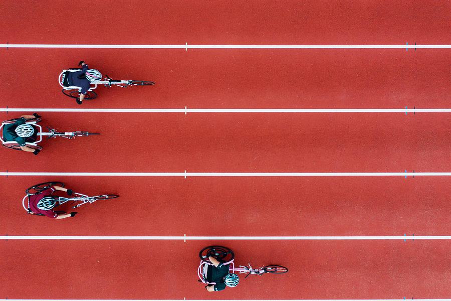 View from directly above four women racing in wheelchairs Photograph by Trevor Williams