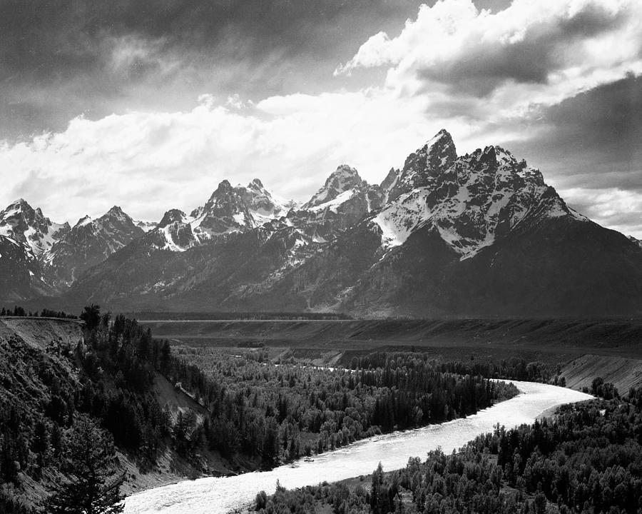 View from river valley towards snow covered mountains, river in foreground, Grand Teton National Par Photograph by Ansel Adams