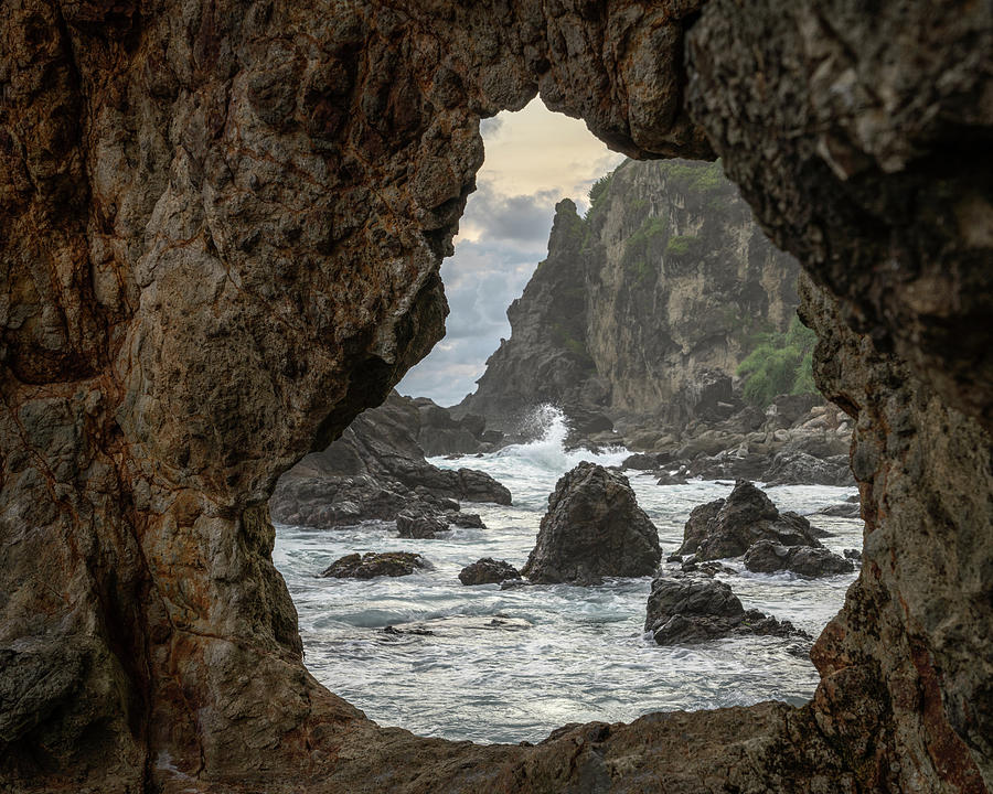 View through a rock at Watu Lumbung beach Photograph by Anges Van der Logt