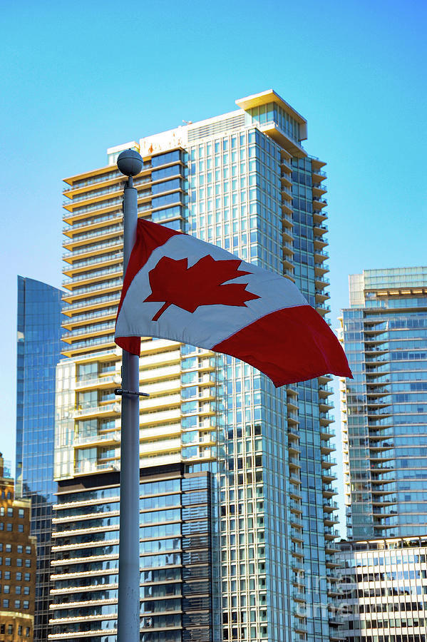 Viewing the Canadian Flag from Vancouver Harbor, one can see downtown Vancouver. Photograph by Gunther Allen
