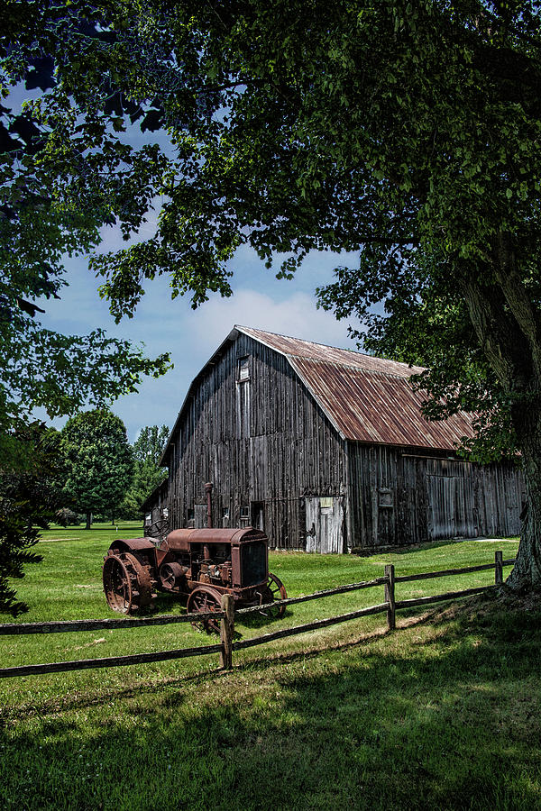 Vintage McCormick-Deering Tractor by old weathed Barn and Wooden Photograph by Randall Nyhof