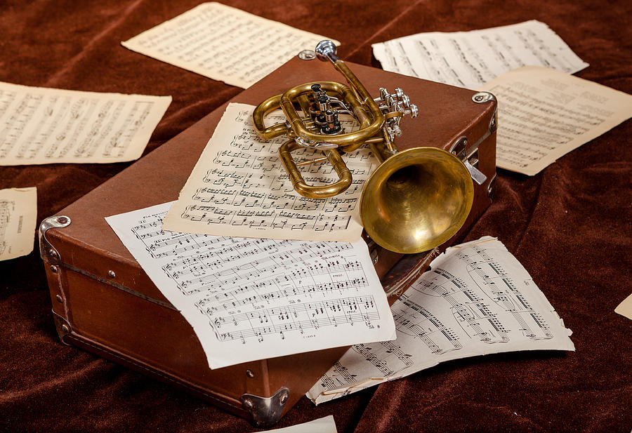 Vintage trumpet is lying between paper sheets with notes Photograph by Kapulya
