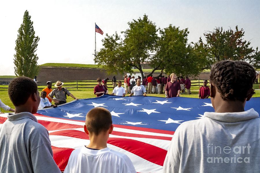 Visitors  from a school tour group hold a large US flag outside of Fort McHenry in Baltimore, MD USA Photograph by William Kuta