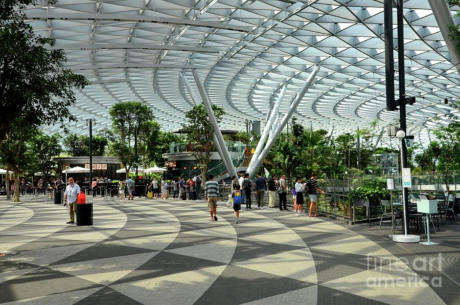 Visitors walk near a cafe inside the Jewel attraction at Singapores Changi Airport Photograph by Imran Ahmed