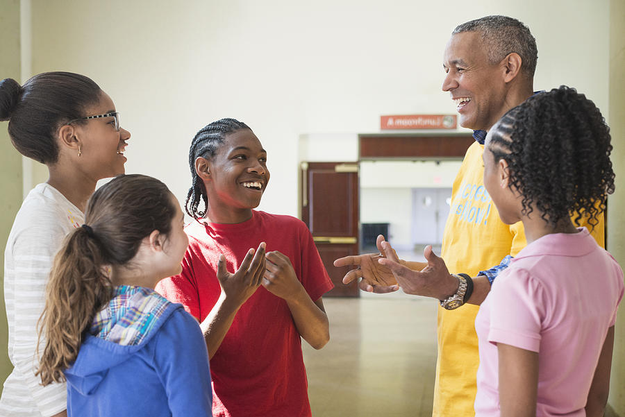 Volunteer talking to children in community center Photograph by Jose Luis Pelaez Inc