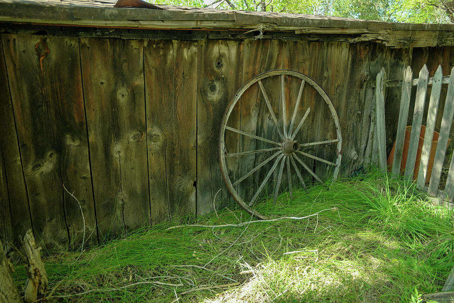 Wagon Wheel Leaning Against A Wall Photograph