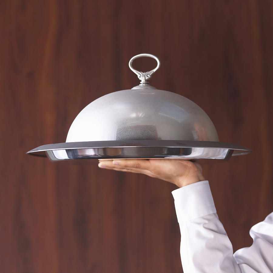 Waiters hand holding domed serving tray Photograph by Burke/Triolo Productions Waiters hand holding domed serving tray Photograph by Burke/Triolo Productions