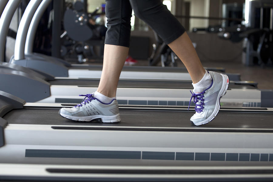 Walking on treadmill Photograph by PhotoAlto/Ale Ventura