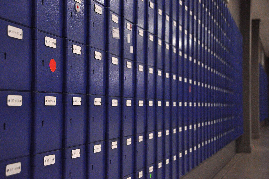 Wall of blue mailboxes marked by red dot Photograph by Lauren Barkume