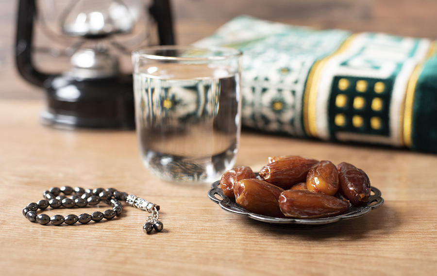 Water and dates. Iftar is the evening meal. View of decoration Ramadan Kareem holiday carpet background Photograph by Snjewelry