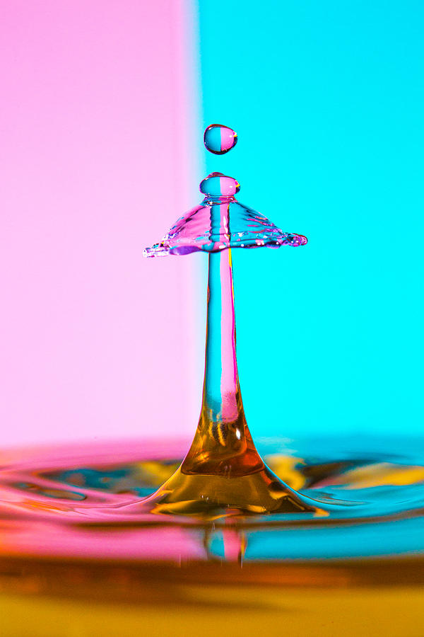 Water Drip on a pink and blue striped backdrop Photograph by Robbie Goodall