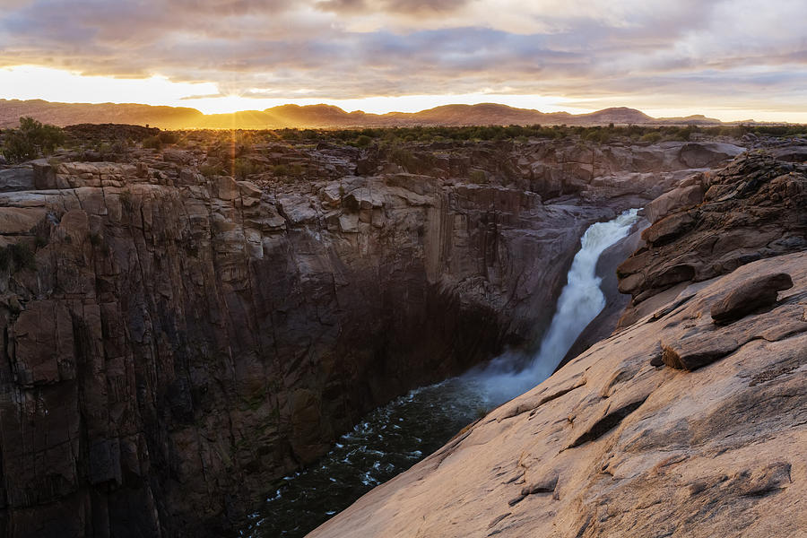 Waterfall flowing over rocky cliffs in remote landscape Photograph by Jeremy Woodhouse