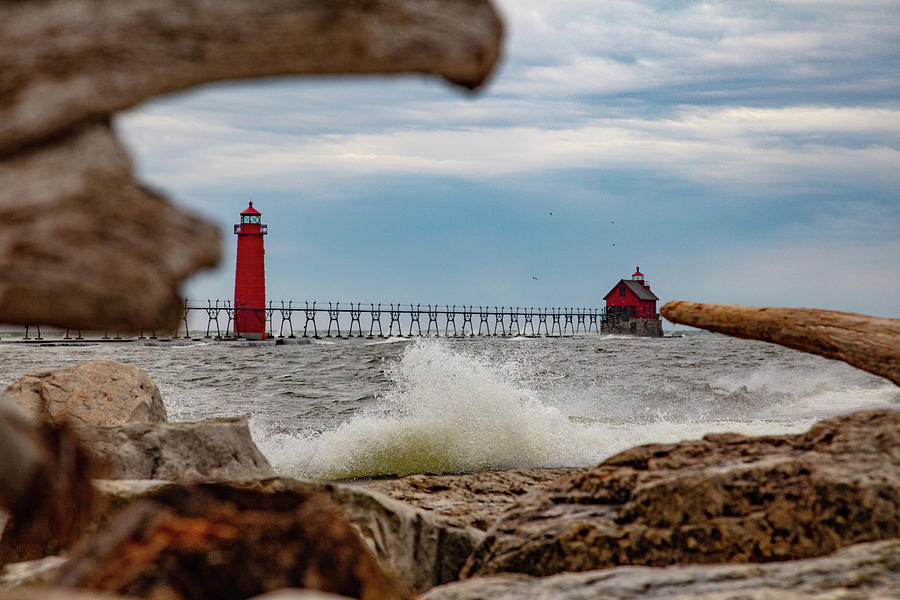 Wave crashing through driftwood view of Grand Haven Pier in Michigan Photograph by Eldon McGraw