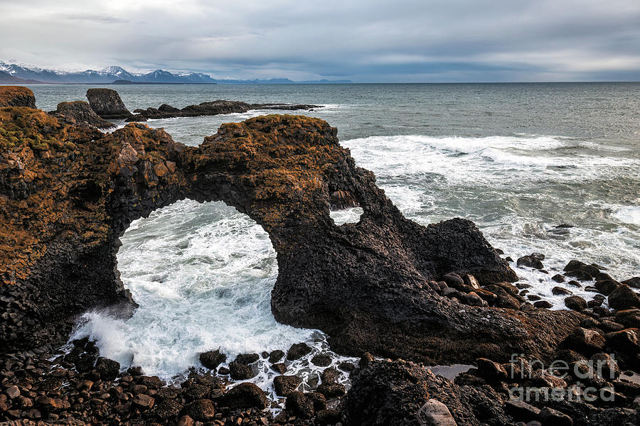 Waves crash trough Gattlekur, or the Hellnar Arch, a natural sto Photograph by Jane Rix