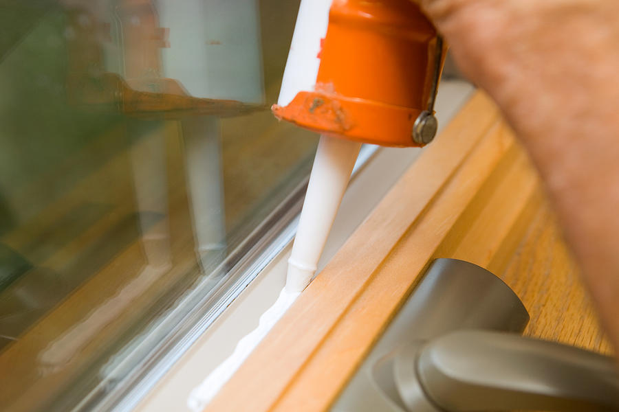 Weather Seal Caulk being applied to Window Frame Photograph by BanksPhotos