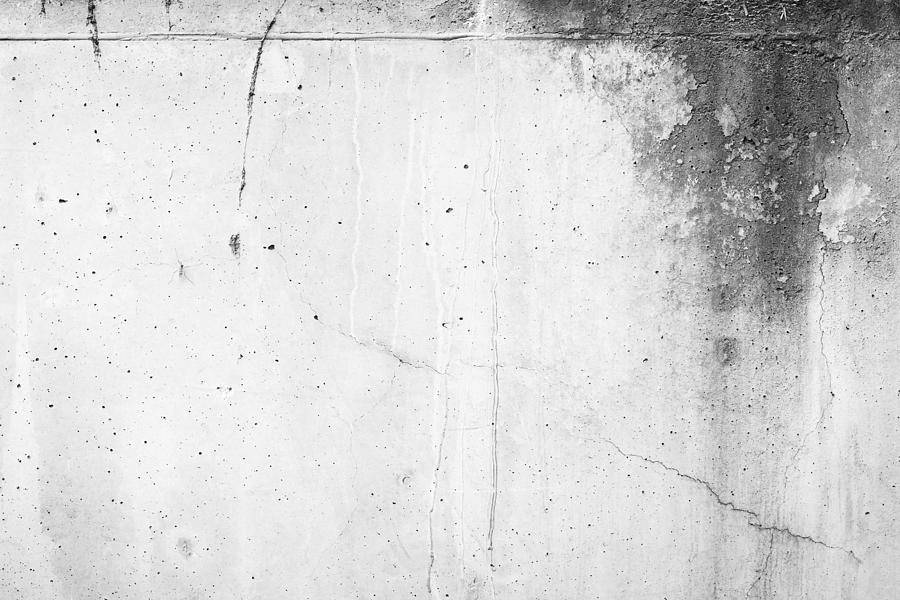 Weathered and moldy concrete wall with cracks in black&white. Photograph by Tuomas A. Lehtinen