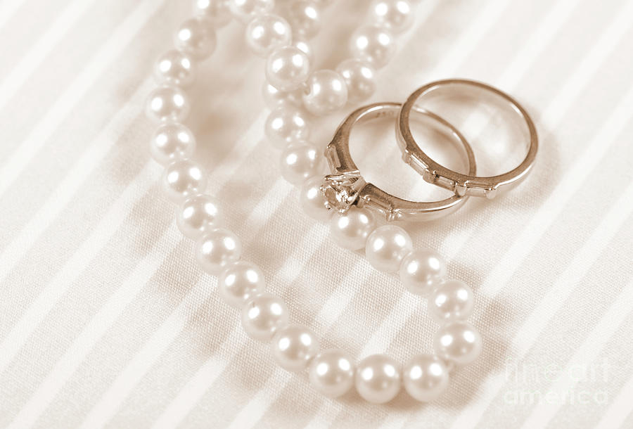 Wedding and diamond engagement rings with pearl necklace Photograph by Milleflore Images