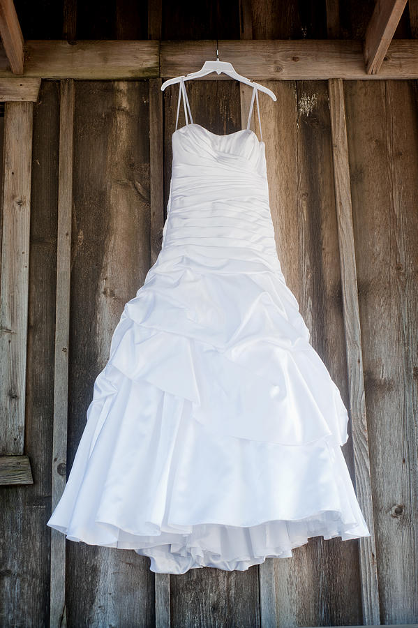 Wedding dress hanging against old wood Photograph by Jade Brookbank