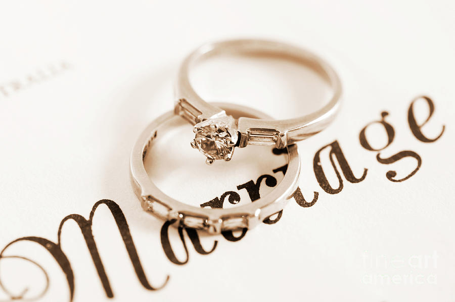 Wedding rings on marriage certificate. by Milleflore Images