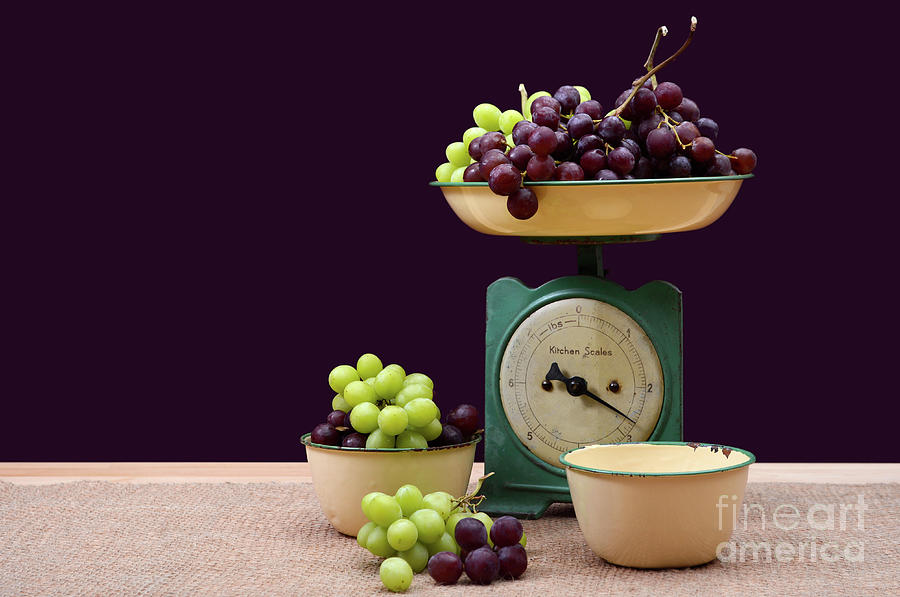 Weighing grapes on vintage scales. Photograph by Milleflore Images