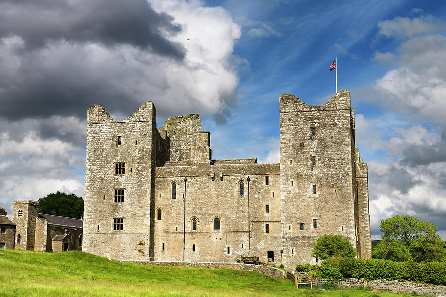 West side of 14th-century Bolton Castle in sun with British flag ...