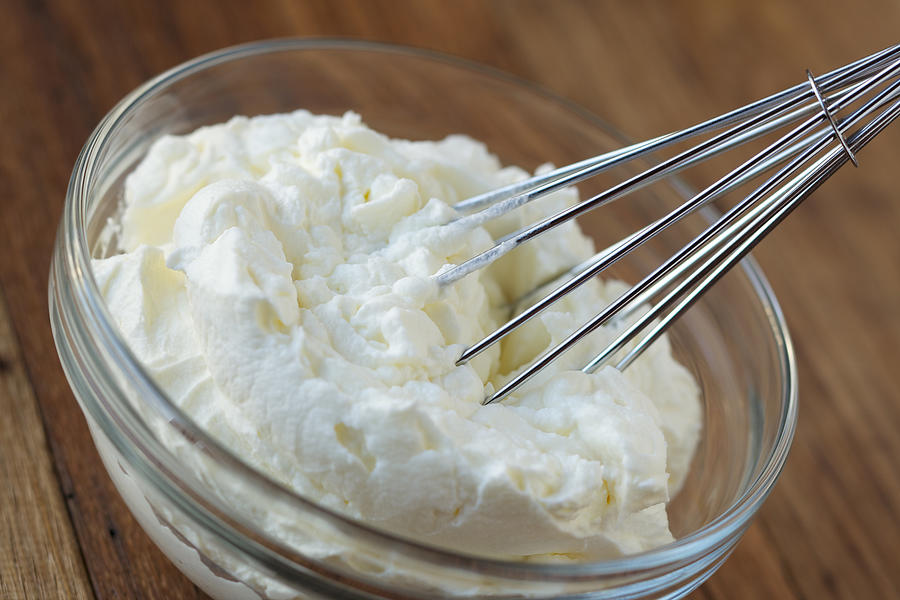 Whipped cream and whisk in glass bowl Photograph by Billnoll