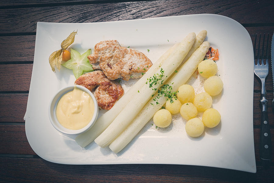 White asparagus with meat and potatoes Photograph by Yulia-Images