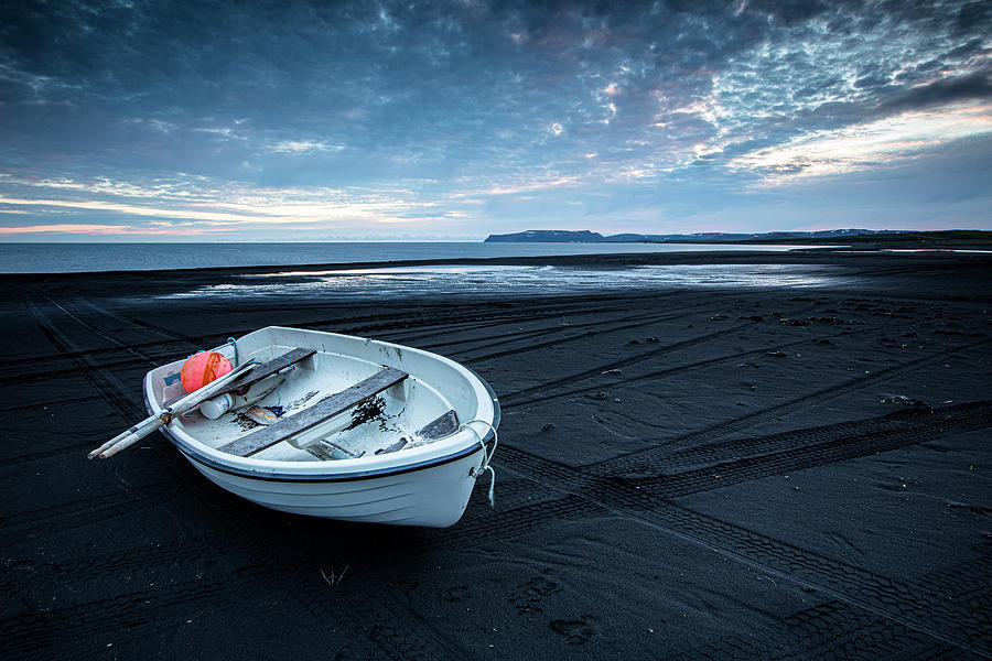 White boat in black sand beach Photograph by Ruben Vicente