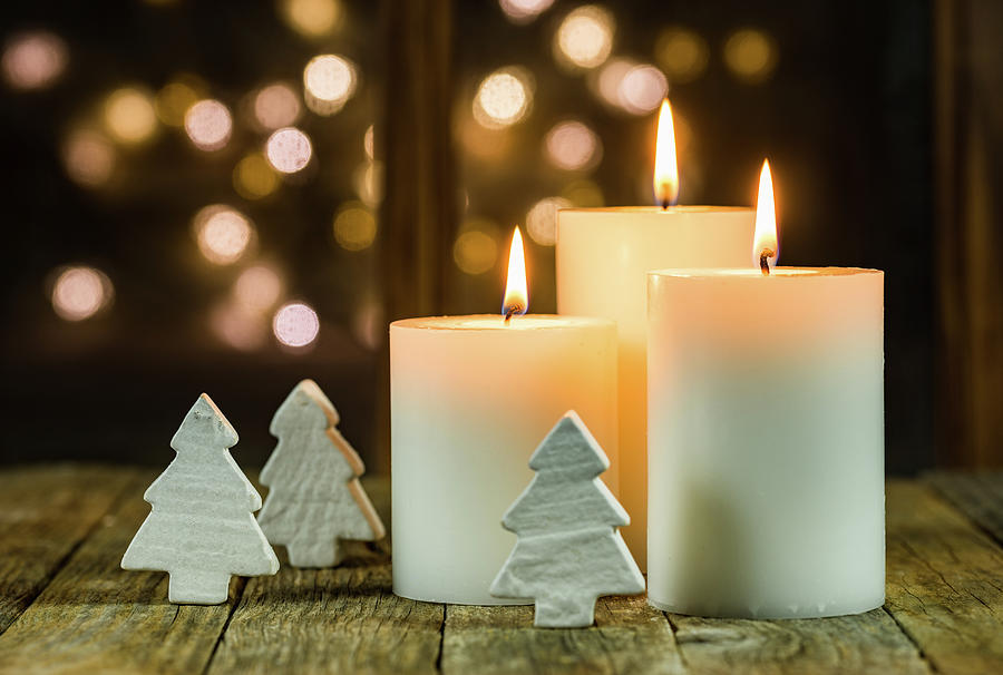 White Christmas candles with ornaments and blurred lights background ...