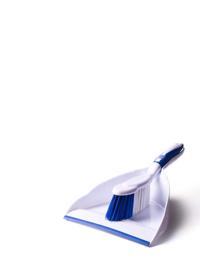 White dust pan and brush on white background. Photograph by Peter Dazeley
