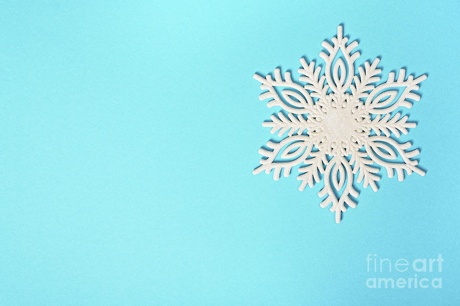 White glittery snowflake on pastel blue background Photograph by Mendelex Photography